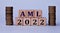 AML 2022 - acronym on wooden cubes on a light background with coins