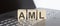 AML abbreviation stands for Anti Money laundering written on a wooden cube on laptop