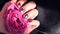 AMOR word on nails manicure hold Pink rose flower on black silk fabric. Minimal flat lay nature. Female hand. Love