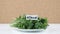 Amount of calories in parsley, male hand puts a plate with the number of calories on a parsley