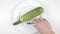 Amount of calories in zucchini, male hand puts a plate with the number of calories on a zucchini, top shot