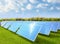 amount of solar panels on green field or solar farm againt blue sky