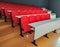 Amphitheater red chairs and white tables for students lined in rows for university or conference lectures