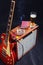 Amplifier for electric guitar with guitar, glass of beer and smoking cigarette on black background