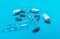 Ampoules for injection and many capsules on a light blue background. The concept of medical assistance.