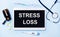Ampoules, pills, stethoscope, thermometer, tablet with STRESS LOSS text on desktop.