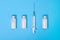 Ampoules with white powder and a medical syringe on a blue background. Antibiotics for the treatment of disease and coronavirus.