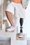 Amputee man with above knee leg prosthesis standing on feet, close up.