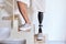 Amputee man with above knee leg prosthesis standing on feet, close up.