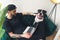 amstaff dog sitting beside his male owner who is working from home home background medium full shot