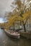 Amsterdam in autumn - narrow boats on a canal; cloudy day.