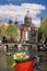 Amsterdam with basket of colorful tulips against canal in Holland