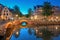 Amsterdam. Blue dusk before dawn. Typical old houses and bridges, illumination. Reflection in water. Amsterdam, Holland,