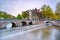 Amsterdam. Bridge and water canal. Boat light trail on sunset. Holland or Netherlands.