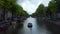Amsterdam Canal with Boat and Dutch Flag waving in wind, forward Aerial