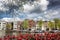 Amsterdam city with boats on canal against red tulips in Holland