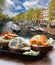 Amsterdam city with fishplate salomon and codfish sandwiches against tourboat on canal in Netherlands