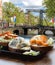 Amsterdam city with fishplate salomon and codfish sandwiches against tourboat on canal in Netherlands