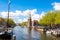 Amsterdam cityscape and the Montelbaanstoren tower on the left. The canal Oudeschans, the Netherlands.