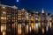 Amsterdam Damrak with the lights on reflecting on the water in the evening in the Netherlands