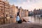 Amsterdam Damrak during sunset, happy woman on a summer evening at the canals