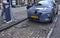 Amsterdam, Holland, August 2019. Along the Amstel river, an electric car is being charged: the cable with the connector connected