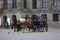 Amsterdam, international tourist destination. Two horses pull a carriage and the coachman chats with a friend he met by chance in