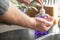 Amsterdam, Netherlands, 03/21/2020. Man washes his hands under the kitchen tap, it is important that you wash your hands several t