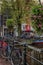 Amsterdam, Netherlands, 12/10/2019: Bicycles on a canal in a European city. Old architecture, flowering trees. Vertical