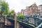 Amsterdam, Netherlands - 15.10.2019: Bicycles on a bridge over the canals of Amsterdam. Colorful houses and flowers. Autumn