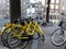 Amsterdam, Netherlands - December 12 2018: Yellow bike bicycle hire in Amstetdam. 3 hire bikes chained to a lamppost