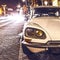 AMSTERDAM, NETHERLANDS - JANUARY 5, 2016: Vintage white car parked in center of Amsterdam at night time. January 5, 2016 in Amster