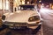 AMSTERDAM, NETHERLANDS - JANUARY 5, 2016: Vintage white car parked in center of Amsterdam at night time. January 5, 2016 in Amster