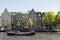 Amsterdam, The Netherlands, May, 2018: Amstel River waterfront on a sunny day with typical houses and boats along the river.