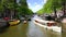AMSTERDAM, THE NETHERLANDS : ULTRA HD 4k, Real time; Boats sail in Amsterdam canal in Amsterdam.