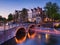 Amsterdam, Netherlands. View of houses and bridges during sunset. The famous Dutch canals and bridges. A cityscape in the evening.
