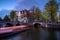 Amsterdam by night with floating boats on the river canal , evening time , travelling to Netherlands