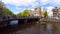 Amsterdam, Panoramic view of Bridge over Amstel river with people and bicycles