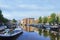 Amsterdam scenery with house-boat and ancient gabled houses at daybreak, Netherlands