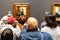 Amsterdam-Visitors looking at the painting milkmaid by Johannes Vermeer