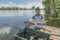 Amur fishing. Fisherman with grass carp fish in hands at lake