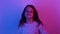 amused child joyful girl jumping in neon light