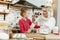 Amused good-looking blonde mother having fun with baking ingredients