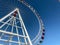 Amusement park. ferris wheel made of white metal. a huge wheel with booths for tourists in white and red. carousel ride