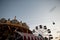 Amusement park with a vintage carousel with lights and a ferris wheel with colorful booths in the evening. Amusement park