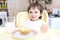 Amusing baby eating cupcake and milk