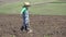 Amusing child with farmer hat gardening with hoe, finish the job