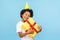 Amusing happy pleased little boy with party cone on head embracing gift box and closing eyes in pleasure