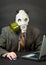 Amusing person in gas mask works with computer