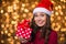 Amusing positive young woman holding one present over shining background